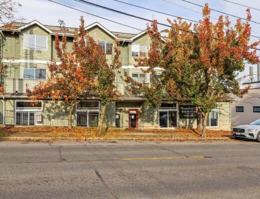 Modern commercial building with autumn trees in front, located in Seattle.